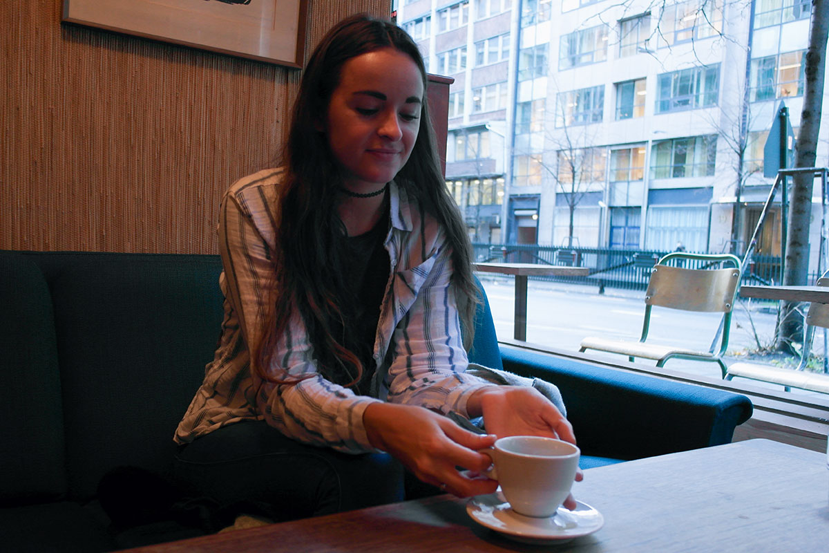 Sophie sitter på kafeen Fuglen i Oslo med en kopp kaffe