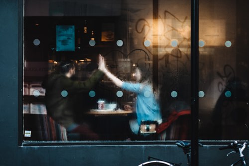 En mann og kvinne på kafe sett gjennom et vindu