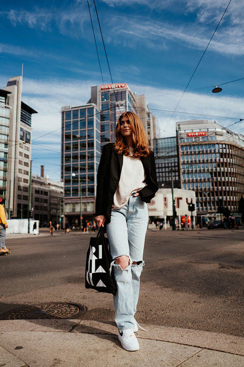 Student som går på gaten med Kristiania-bærenett.