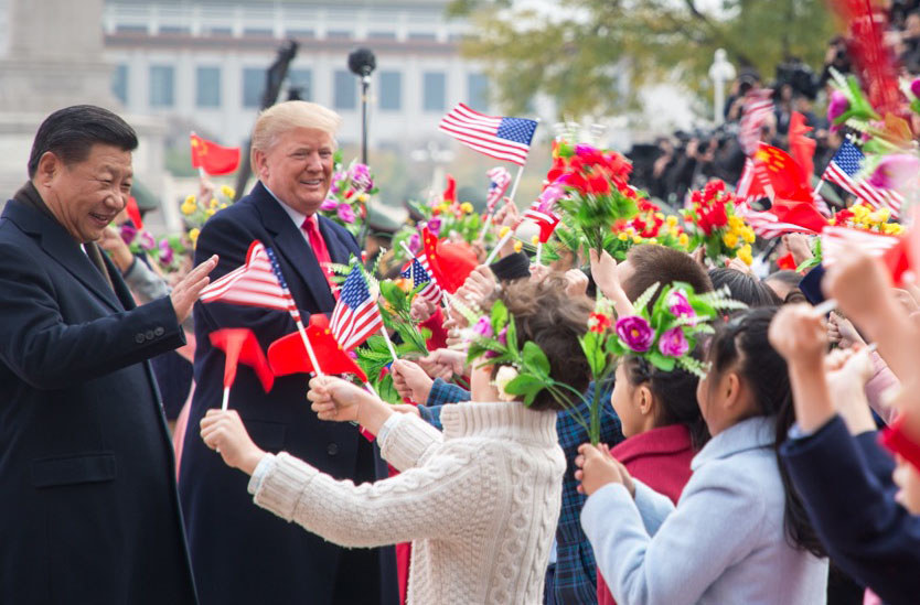 Donald Trump og Xi Jinping møter flere unge barn med kinesiske og amerikanske flagg.