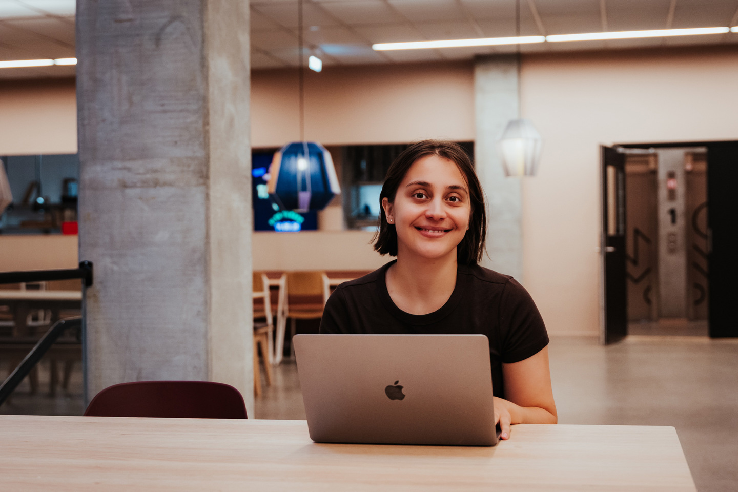 Student med PC ser i kamera.