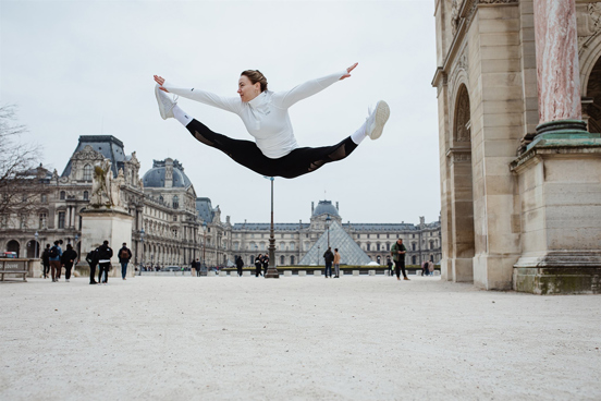 Lise Kristoffersen gjør et splithopp på plassen utenfor Louvres glasspyramide i Paris.