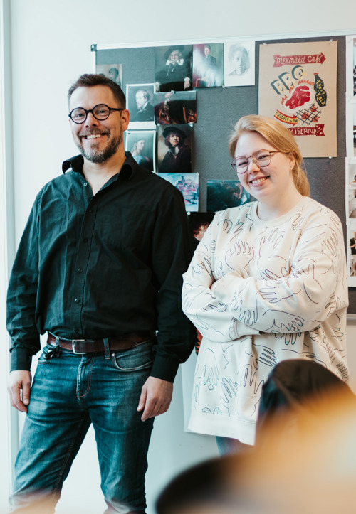 Tor Edvin og Andrea foran plakater på kontor