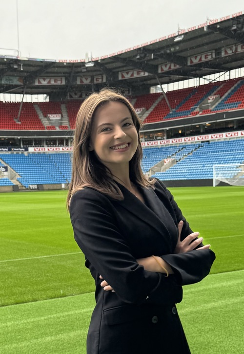 June står på tribunen på Ullevaal Stadion, foran gressmatte og tribunerader.