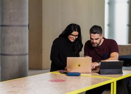 En mann og en kvinne sitter sammen foran en laptop.