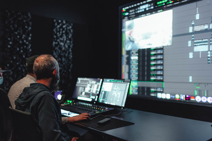 Student og foreleser jobber sammen ved miksepult.