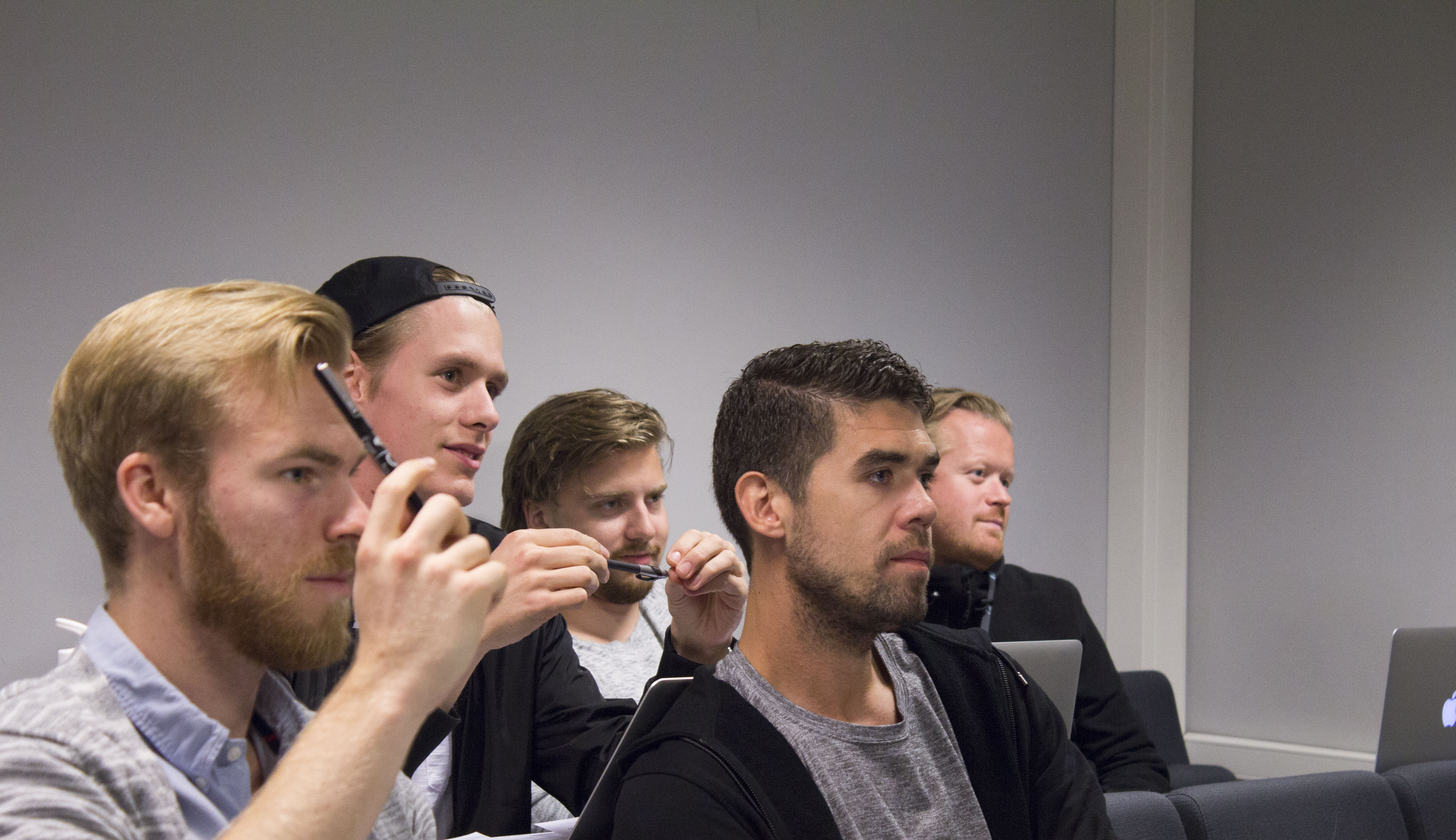 Studenter i et auditorium under en forelesning.