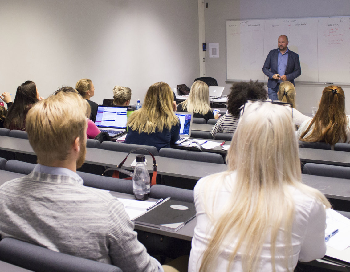 studenter sitter i et klasserom og ser på underviseren