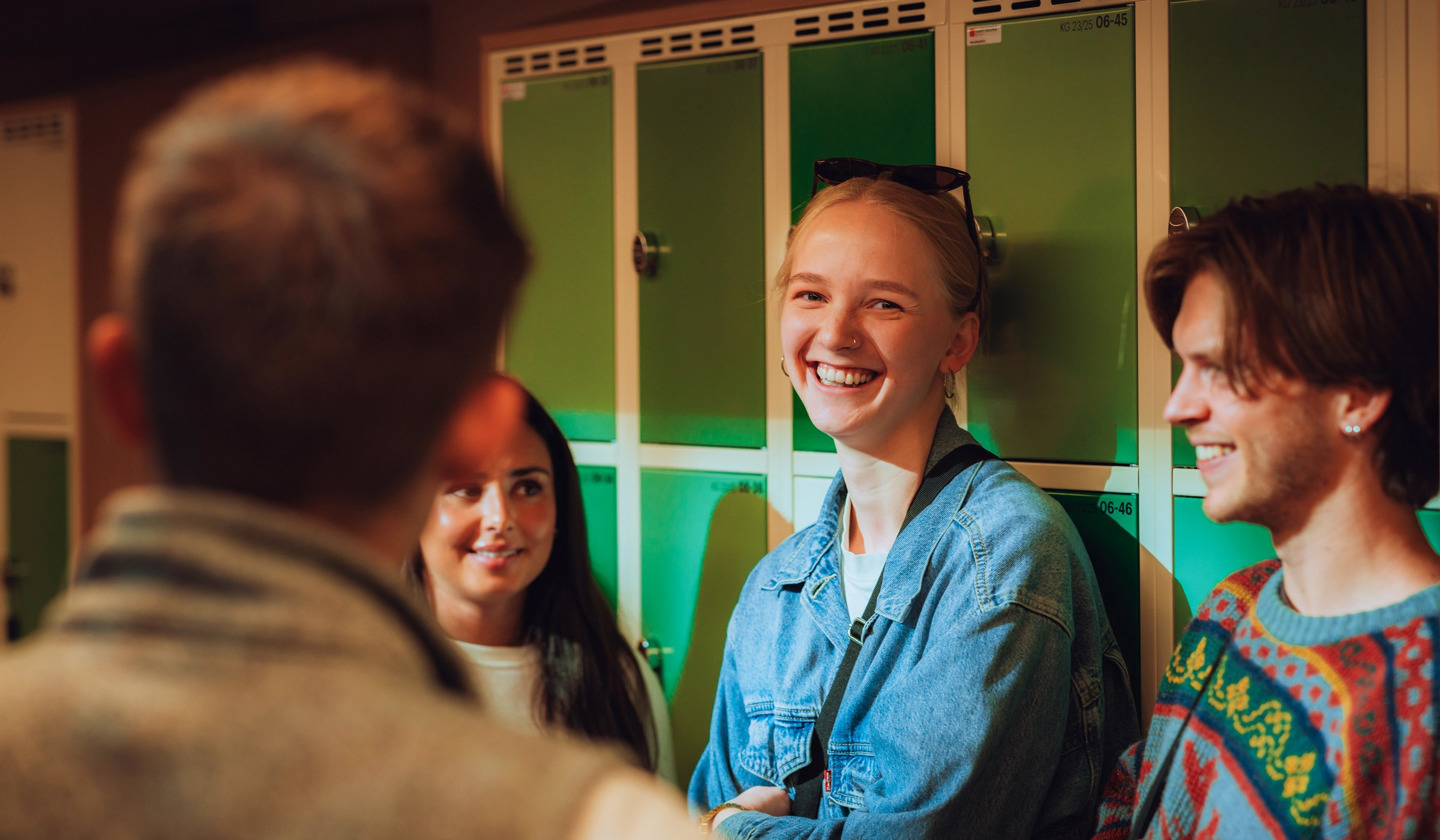 Studenter står ved skapene i gangen på skolen