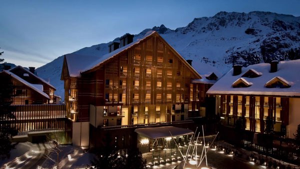 Lyset fra vinduene til luksushotellet The Chedi bryter opp kveldsmørket i den sveitsiske fjellheimen.