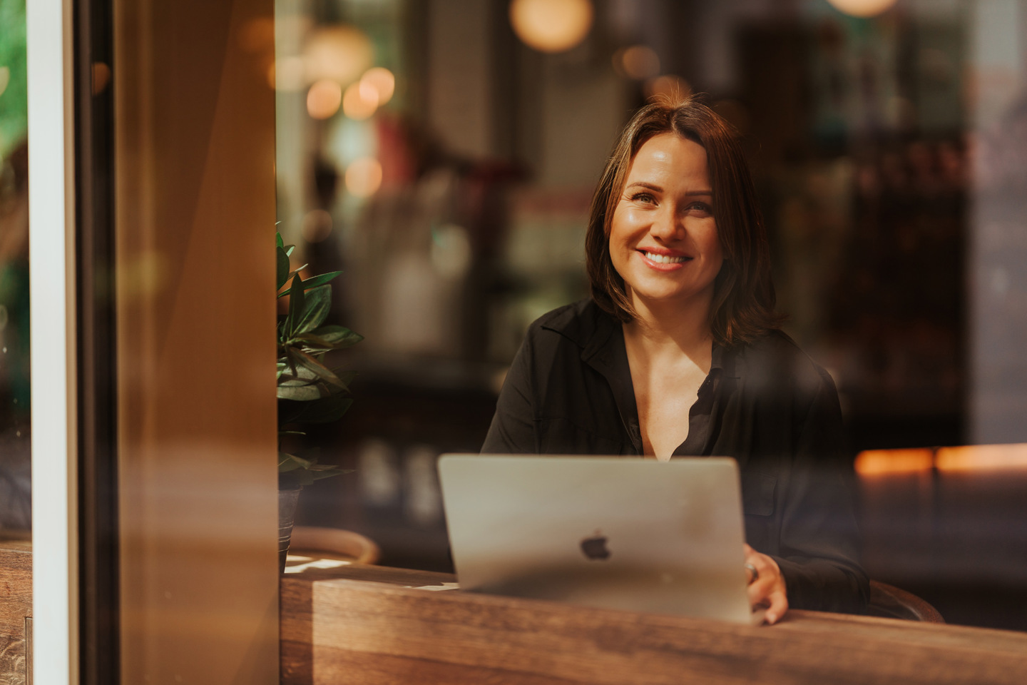 Nettstudent benytter seg av Kristianias fleksible nettstudier og sitter på kafé mens hen jobber.