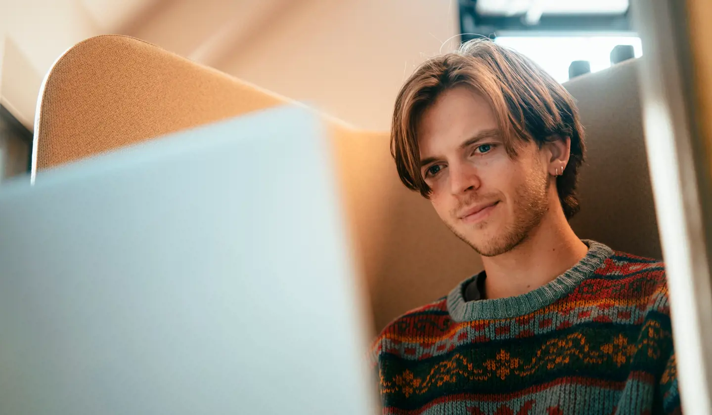 Student jobber med pensum på pc'en sin.