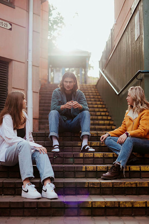 studenter som sitter i en trapp og prater