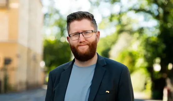 Teknologidirektør Christian Iversen står utenfor kontoret sitt i Oslo og smiler til kameraet