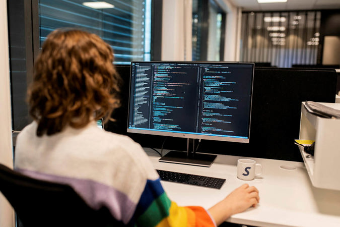 Frontend-utvikler jobber med koding på datamaskin.