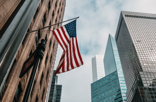 Det amerikanske flagget på stang på en bygning i New York