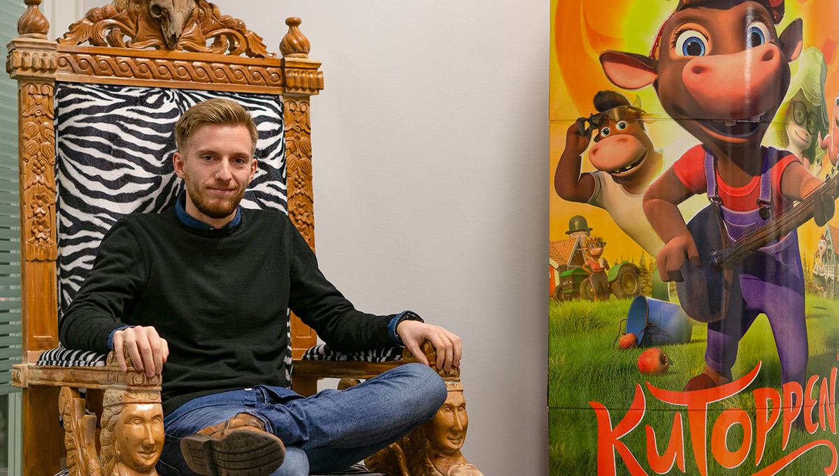 Kristian Karijord Arntzen i en stilig stol med en plakat av Kutoppen