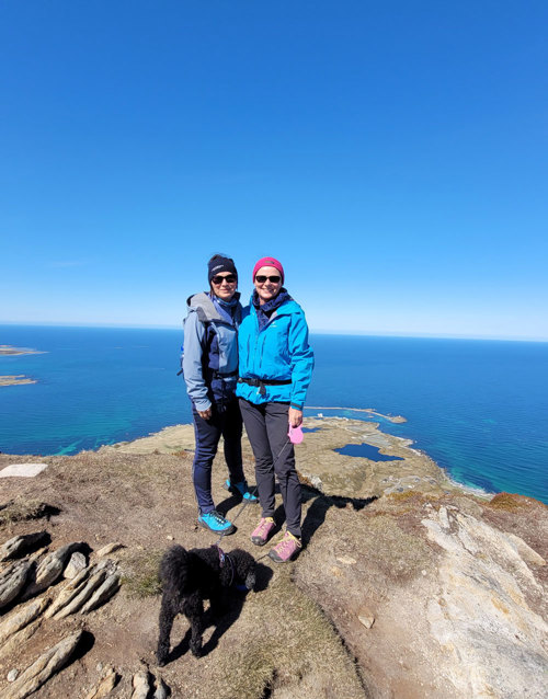 To søstre på en fjelltopp med utsikt til havet.