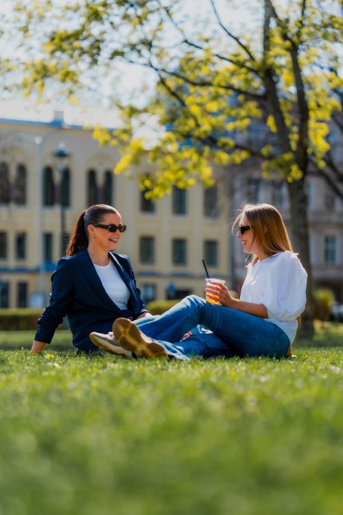 Maren Andrea og en medstudent sitter i parken ved Stortinget.