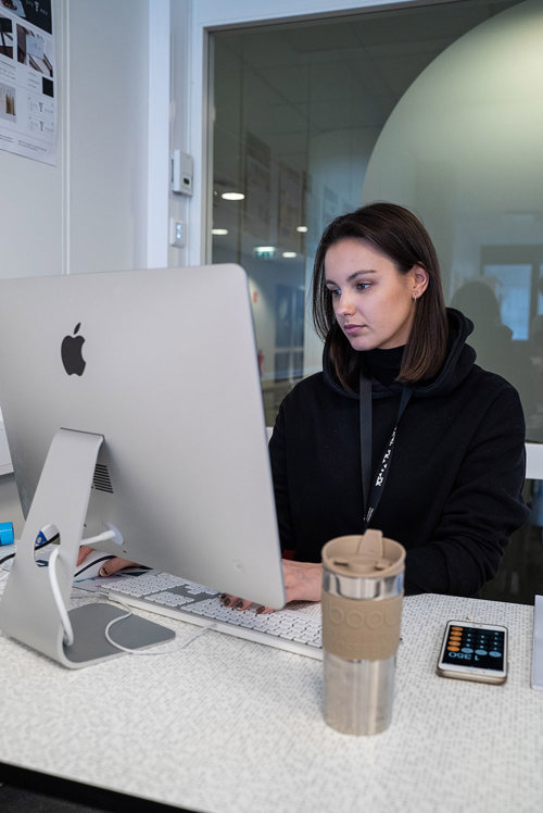 Foto av student Christine Akerø, som arbeider ved en mac.