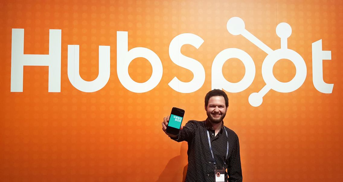 Christopher foran en oransje vegg med hvit HubSpot-logo