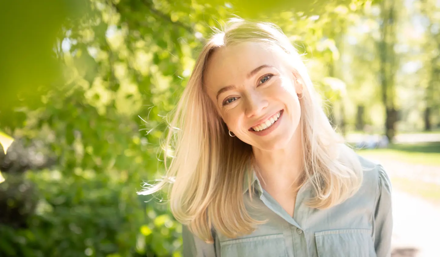 Blond kvinne smiler til kamera