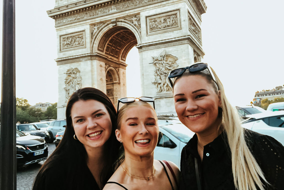 Studenter avbildet foran triumfbuen i Paris.