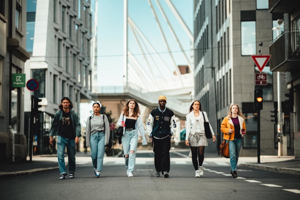 Foto av unge studenter som går over gaten.