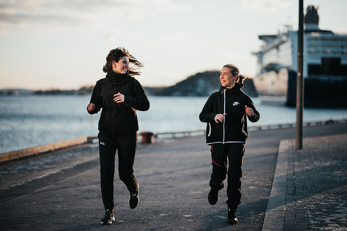 Foto av to løpere på promenade.