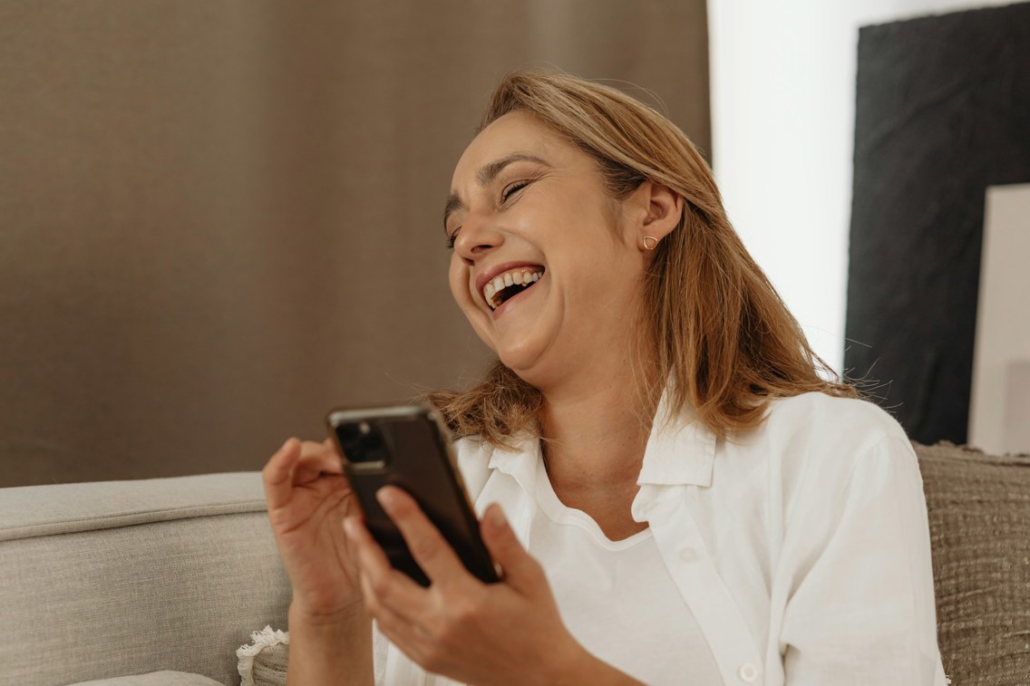 Woman laughing at something on her phone