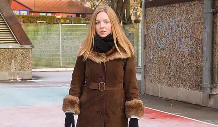Rebekka Jynge står på en idrettsbane med en kåpe på