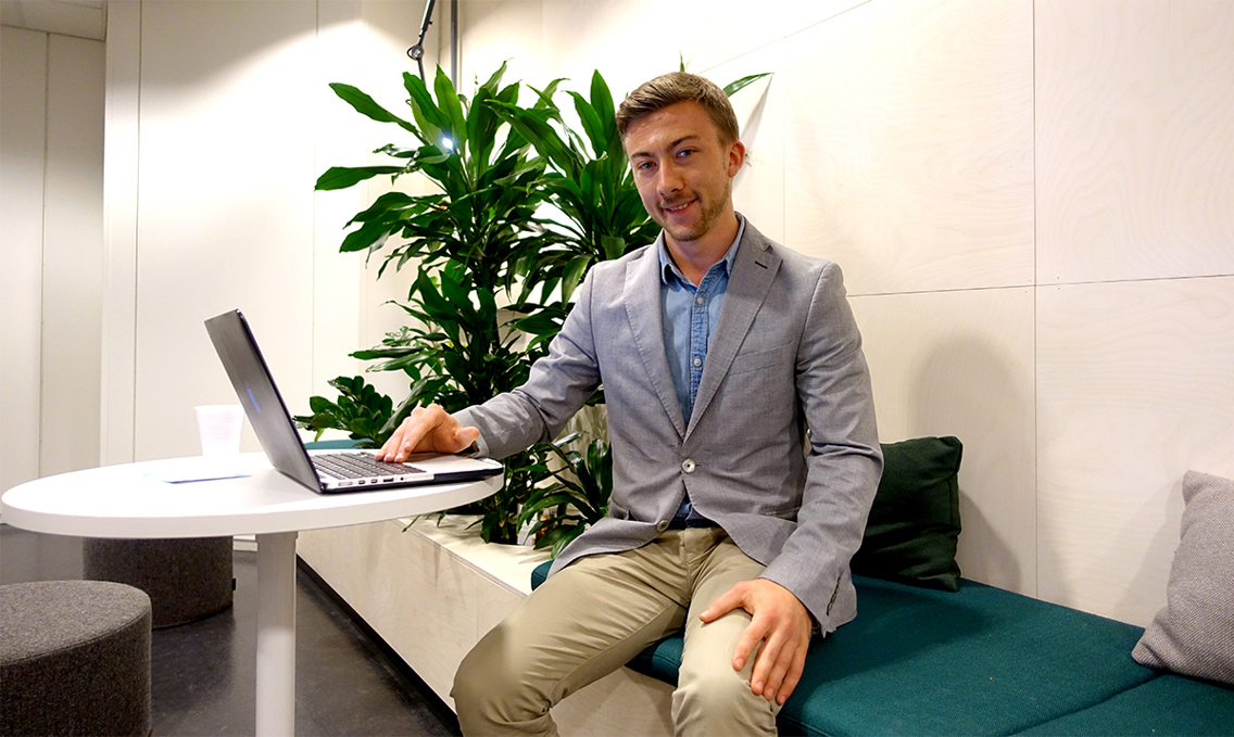 Kristoffer sitter med laptopen foran seg. Han har på seg gjenkneppet blazer og skjorte. Og bukse, så klart. 