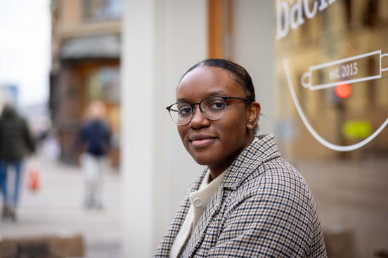 Irene sitter på en benk utenfor en kafé i Kirkegata i Oslo.