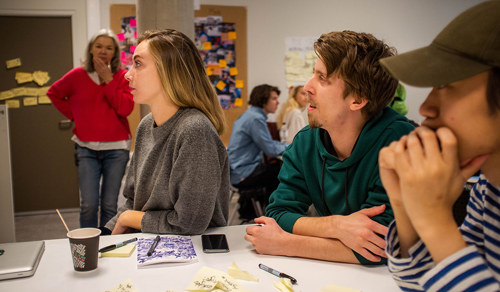 Foto av fire studenter som følger med på undervisning på fagskolen.