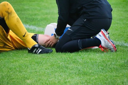 fotballspiller ligger skadet på banen