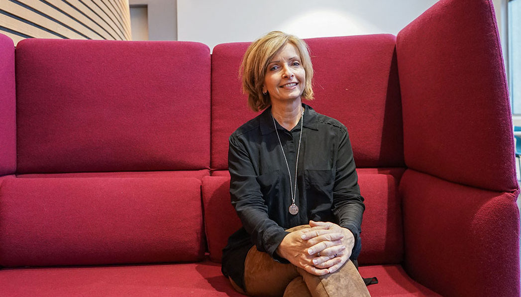 Hanne Kristin Rohde sitter med beina i kryss i en sofa på Høyskolen Kristiania i Bergen. Har på seg svart skjorte og brun bukse.