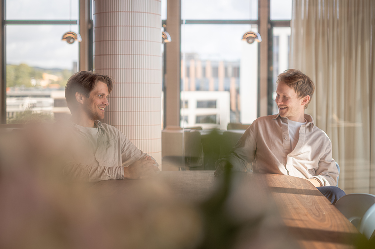 Fredrik Bjørn og Simen sitter i en sofa på et kontor.