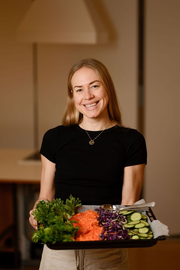 Susanne Tiller holder et fat med oppkuttede grønnsaker.