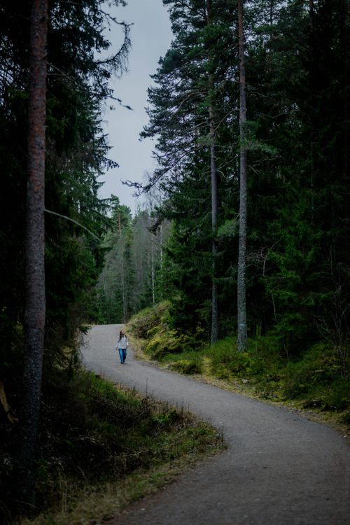 Monica går tur på en gruslagt vei i skogen. 