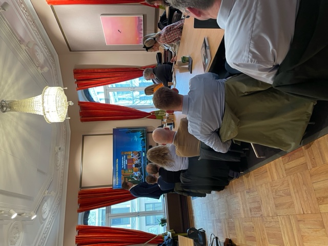 People are sitting and facing Rozemeijer while he holds a presentation. Photo.