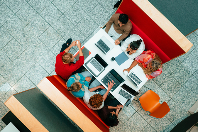 Studenter som jobber sammen rundt et bord med bærbare PC-er