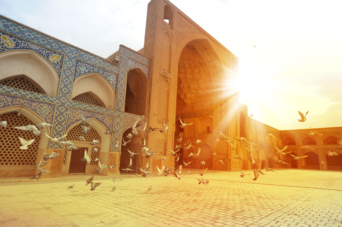 Masjid-i Jami i Isfahan, Iran i kveldssol og duer som letter over plassen utenfor