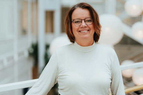 Portrettbilde av en kvinne med mørkt hår og briller