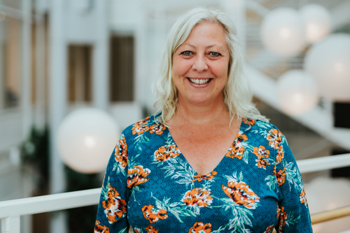 Portrett av kvinne med lyst hår og fargerik topp